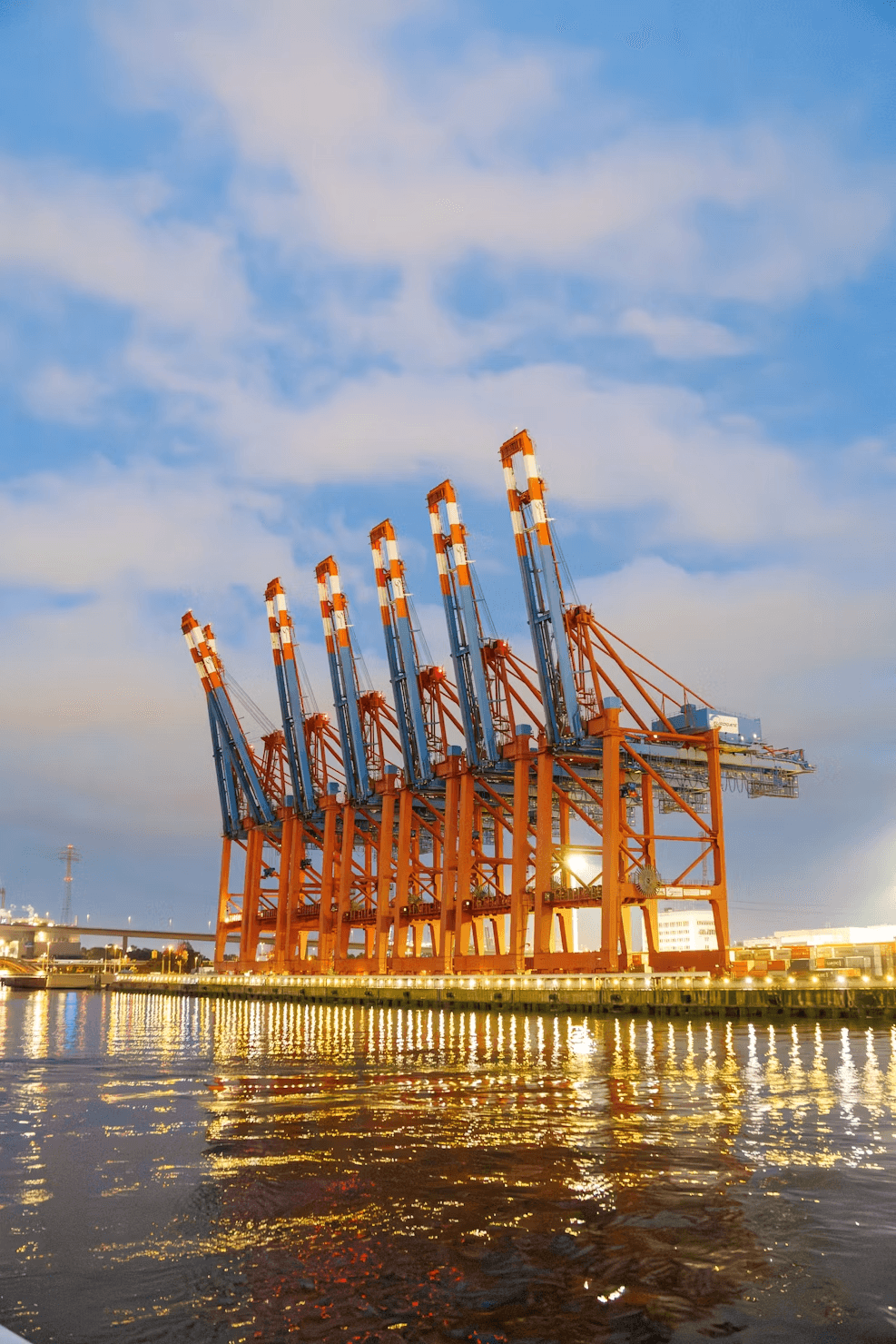 Large cargo cranes at a port at dusk